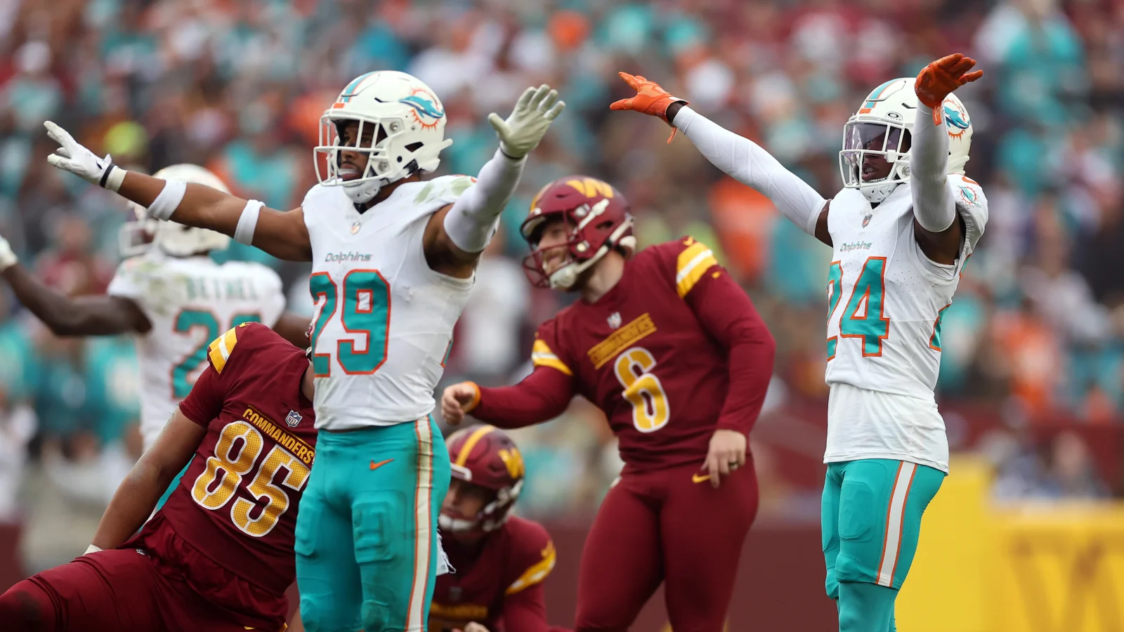 A pair of Miami Dolphins players celebrate the Washington Commanders missing a kick