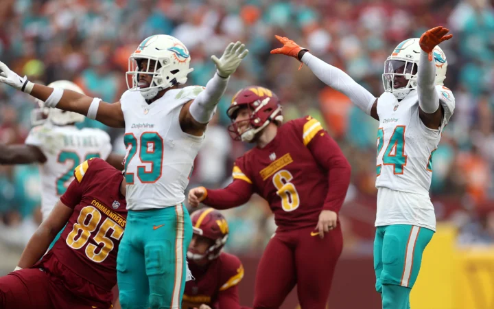 A pair of Miami Dolphins players celebrate the Washington Commanders missing a kick