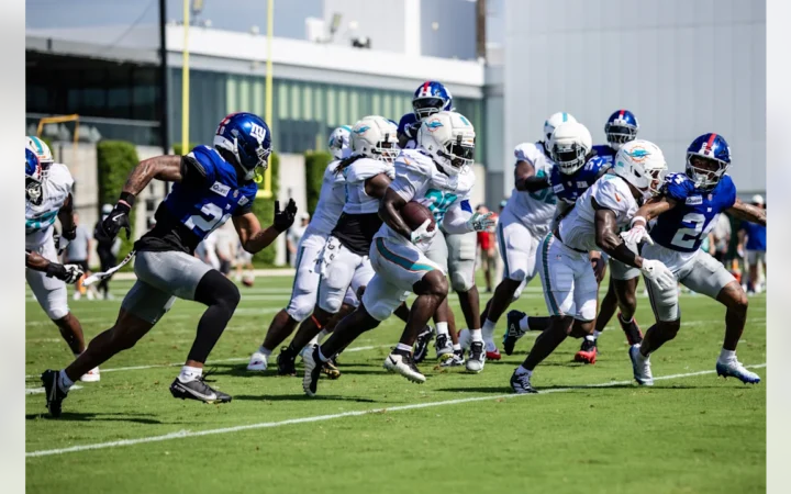 Miami Dolphins RB Devon Achane runs the ball against the New York Giants in joint practice