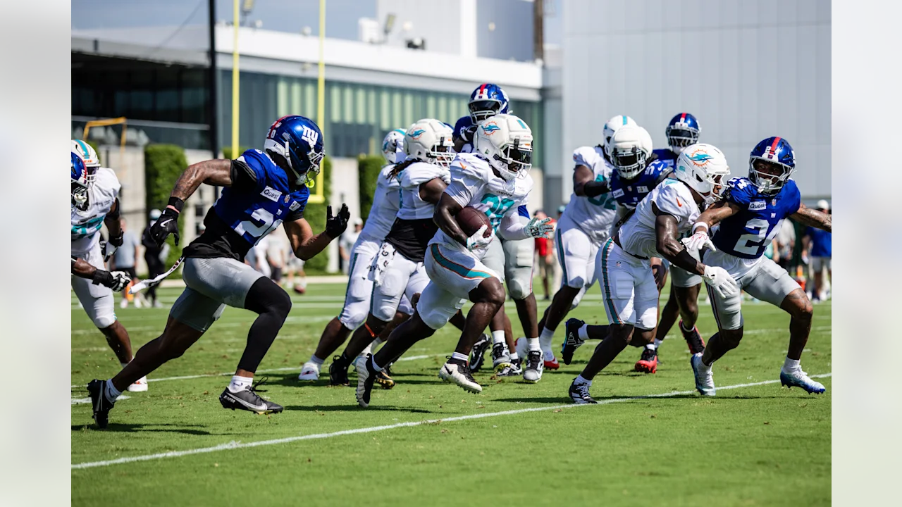 Miami Dolphins RB Devon Achane runs the ball against the New York Giants in joint practice