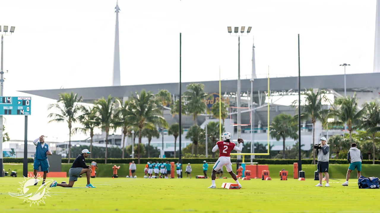 Miami Dolphins QB Malik Willis throws the ball in training, with Hard Rock Stadium in the background
